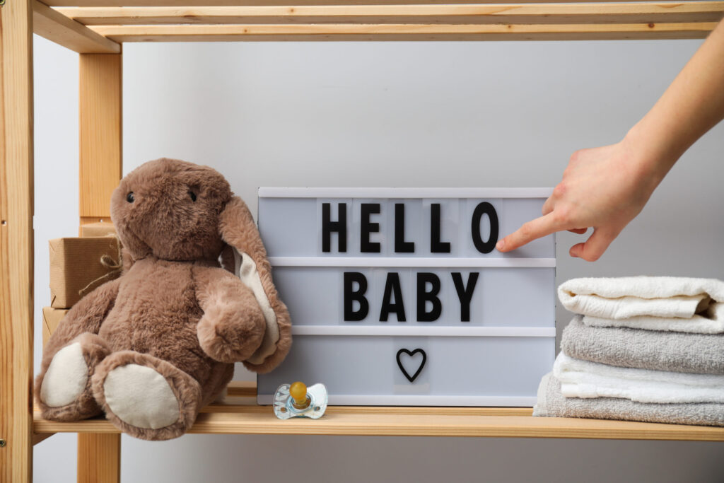 Texte hello baby pointé par le doigt d'un client de LAtelier de Maman, magasin cadeau bébé