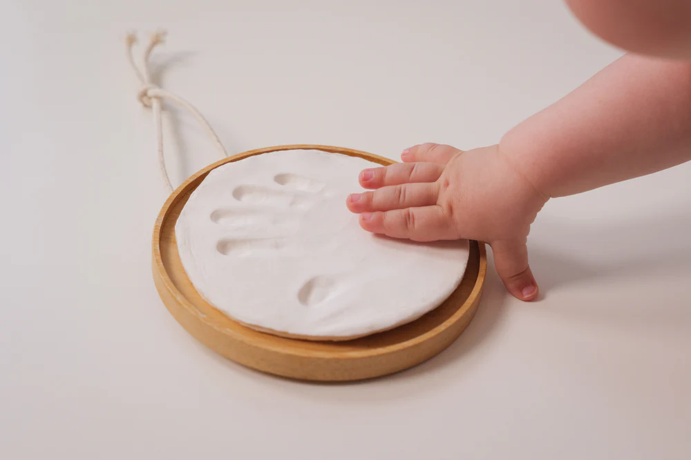 Médaillon en bois avec empreinte de bébé réalisée