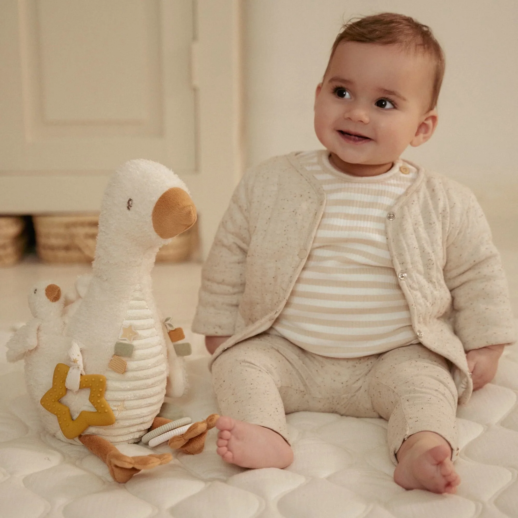 Bébé manipulant la peluche d’activités Oie Newborn