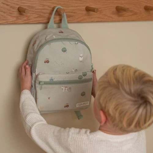 Enfant accrochant le sac à dos Little Dutch Little Farm vert durant la rentrée des classes