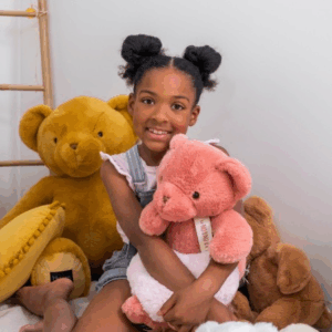 Enfant s’appuyant sur l’ours géant marron clair assis «Le Nounours» Histoire d’Ours