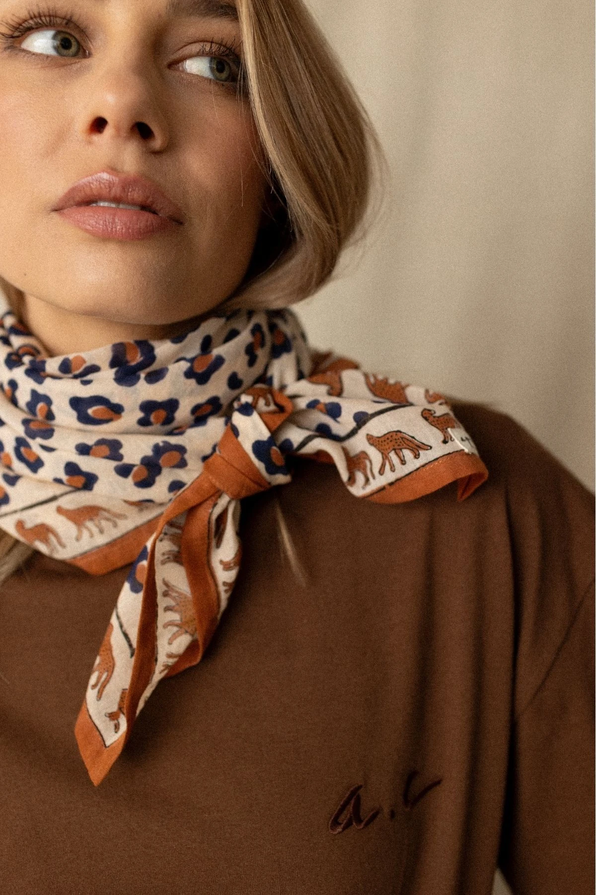 Foulard Léopard Rust porté autour du cou pour un look chic